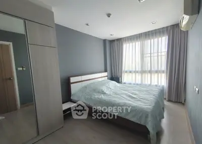 Spacious bedroom with large window and modern decor