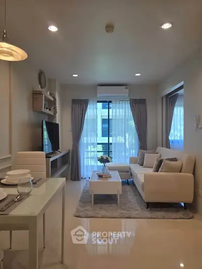 Modern living room with elegant decor and natural light, featuring a cozy sofa and stylish dining area.