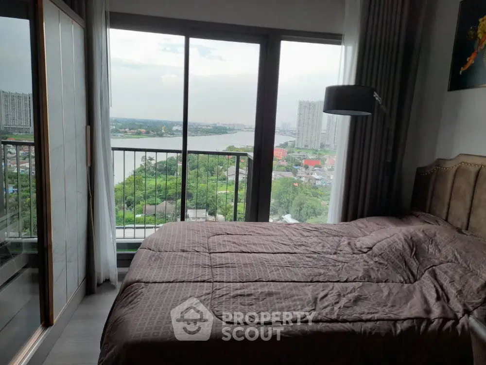 Spacious bedroom with stunning river view and large windows in modern apartment.