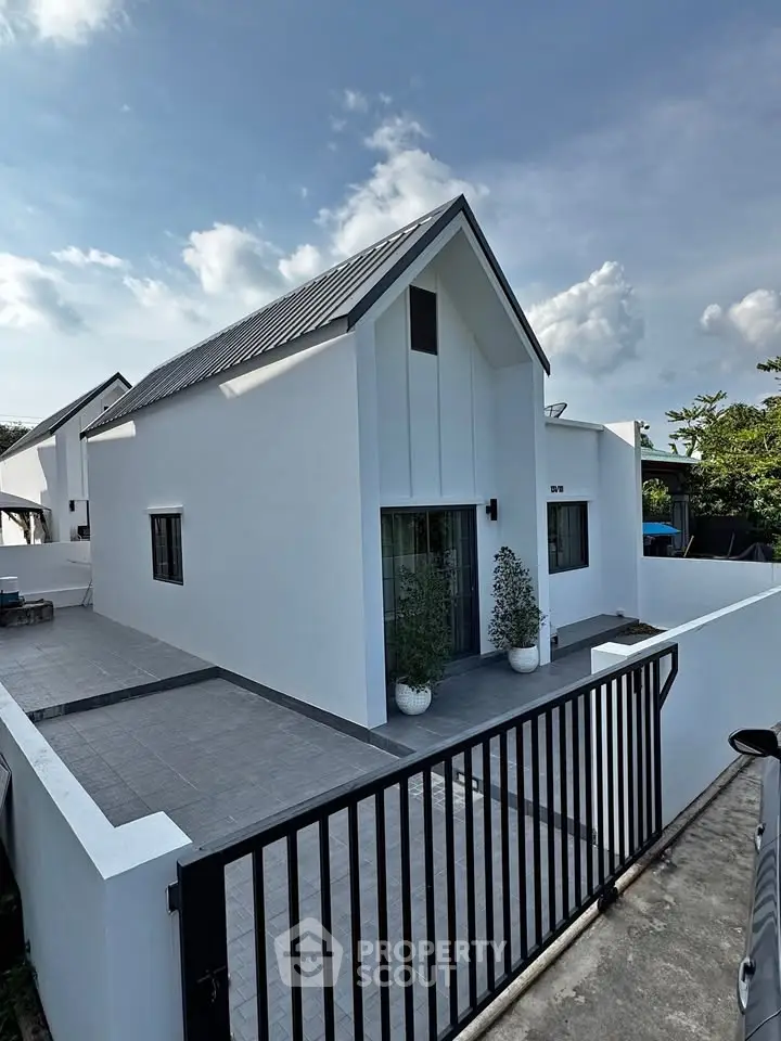 Modern minimalist white house with sleek design and spacious outdoor area.