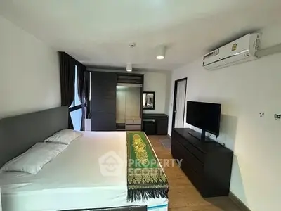 Spacious bedroom with modern furnishings and air conditioning in a stylish apartment.