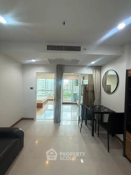 Modern living room with dining area and balcony view in a stylish apartment.