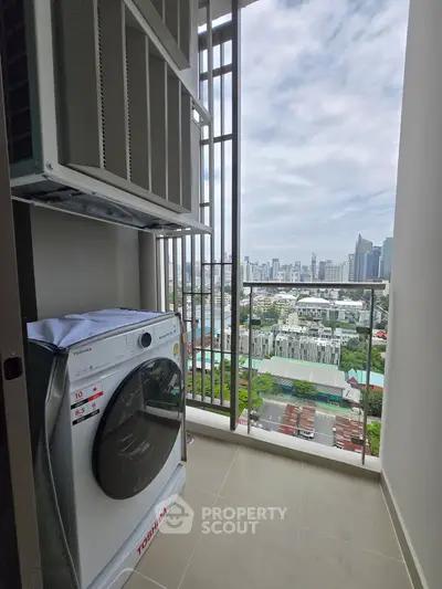 High-rise apartment balcony with washing machine and stunning city skyline view.