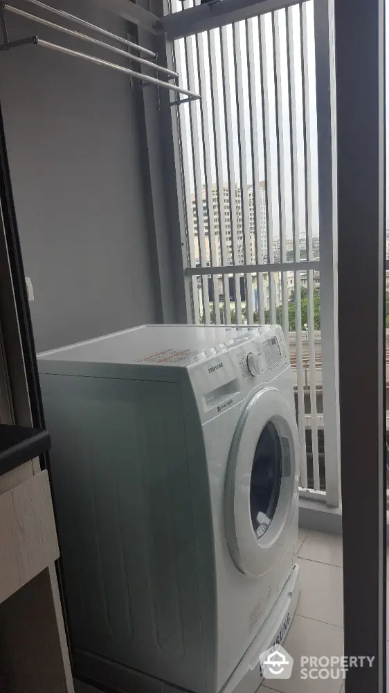 Modern laundry area with washing machine and city view balcony