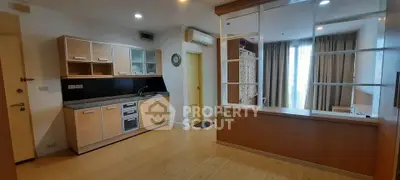 Modern open-layout kitchen with wooden cabinets and sleek appliances in a cozy apartment.