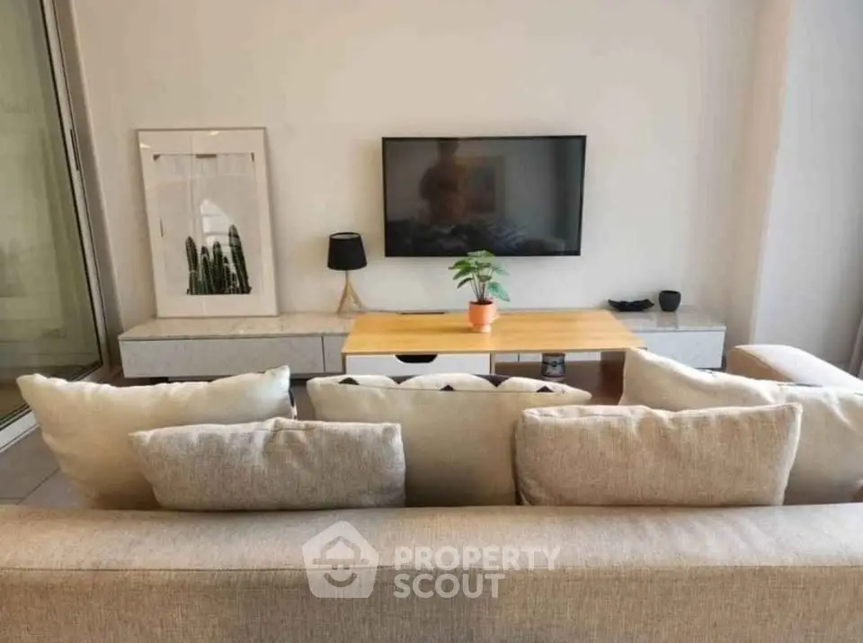 Modern living room with cozy sofa and wall-mounted TV, perfect for relaxation.