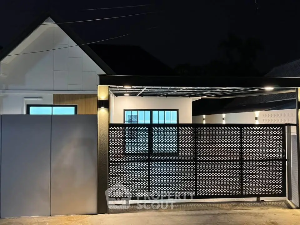 Modern house exterior with stylish gate and ambient lighting at night