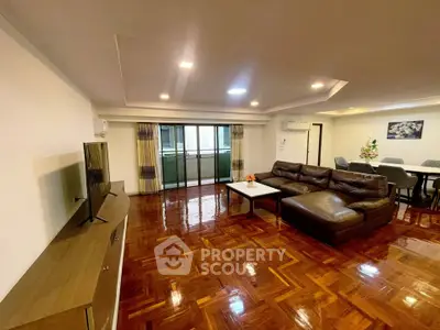 Spacious living room with polished wooden floors and modern furniture in a luxurious apartment.