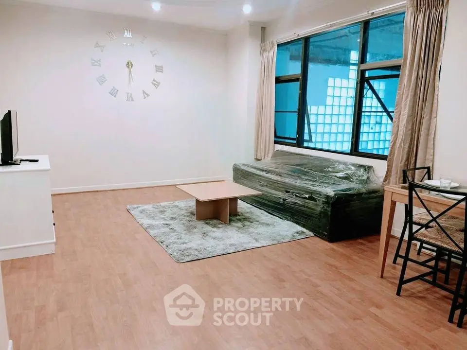 Spacious living room with modern decor and large windows in a stylish apartment.