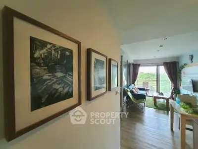Charming living room with balcony view, cozy seating, and elegant wall art.