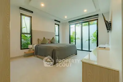 Spacious modern bedroom with large windows and garden view