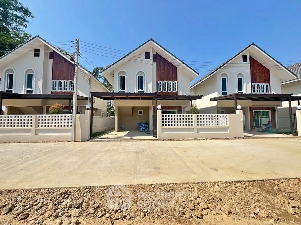 Charming modern houses with gable roofs and spacious driveways in a serene neighborhood.