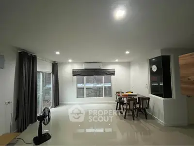 Spacious modern living room with large windows and dining area
