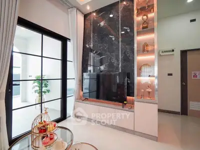 Luxurious living room with marble accent wall and elegant decor, featuring large windows and stylish furniture.