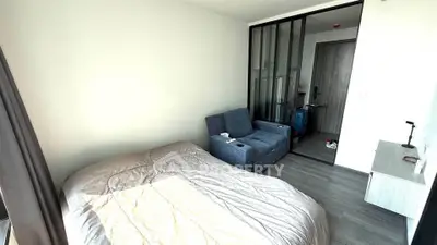 Modern bedroom with cozy bed and stylish armchair in a bright apartment