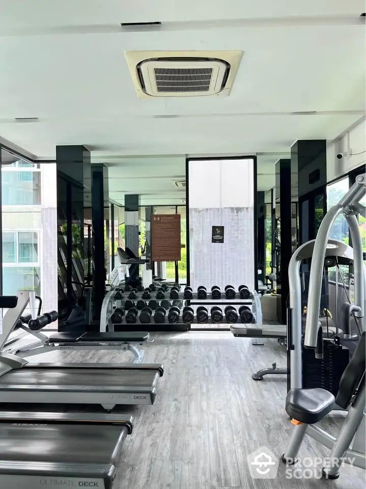 Modern gym with state-of-the-art equipment and mirrored walls in a luxury apartment complex.