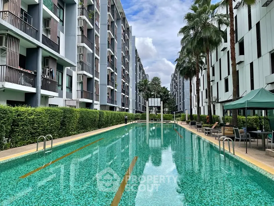 Luxurious apartment complex with stunning outdoor pool and lush greenery.