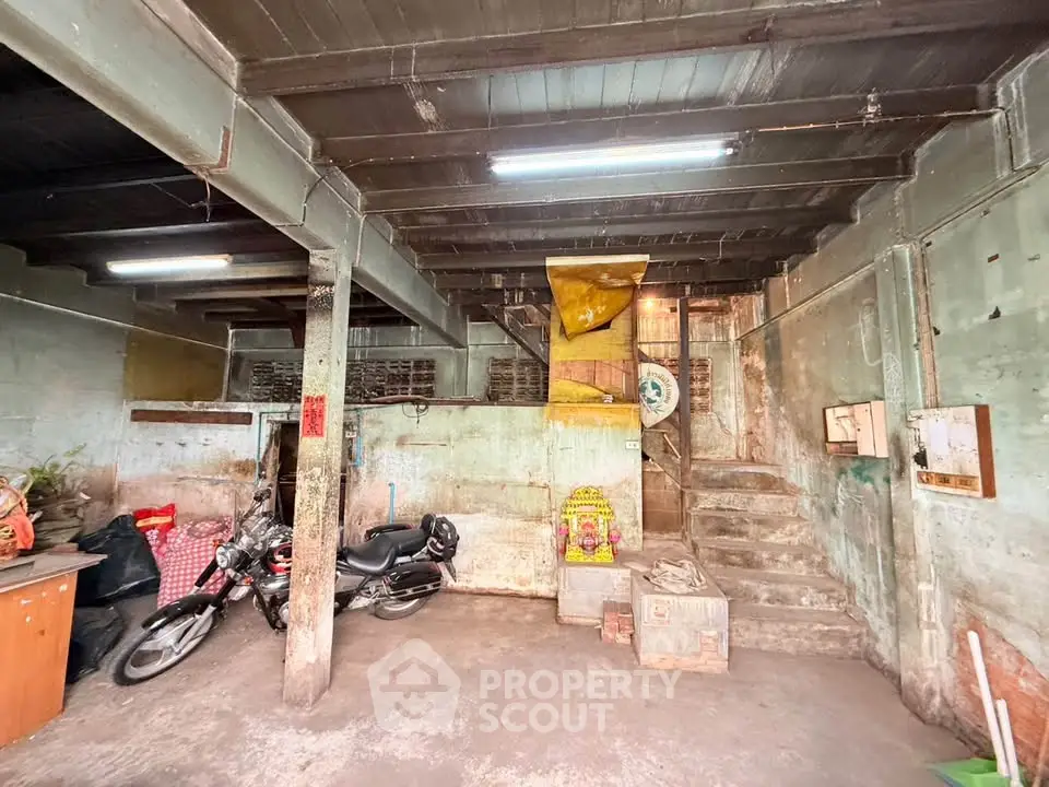 Rustic basement with exposed beams and motorcycle storage, ideal for renovation or creative use.