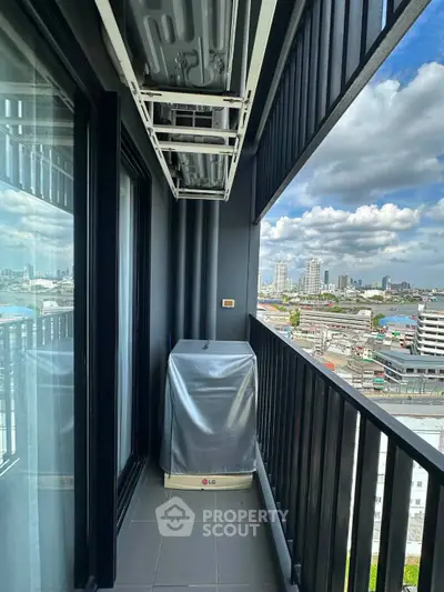 Modern high-rise balcony with city skyline view and covered appliance
