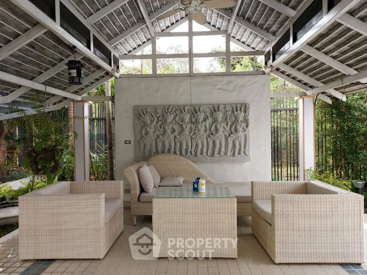 Charming outdoor patio with elegant wicker furniture and artistic wall decor