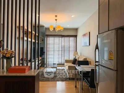 Modern living room with stylish decor and open kitchen layout, featuring a cozy sofa and elegant lighting.