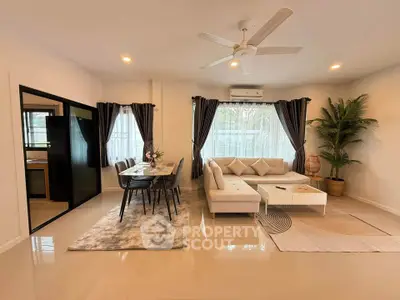 Spacious modern living room with elegant dining area and cozy seating, perfect for family gatherings.