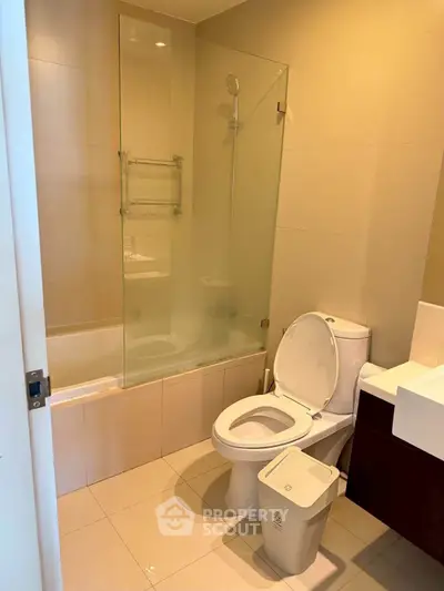 Modern bathroom with glass shower and sleek fixtures in a contemporary apartment.