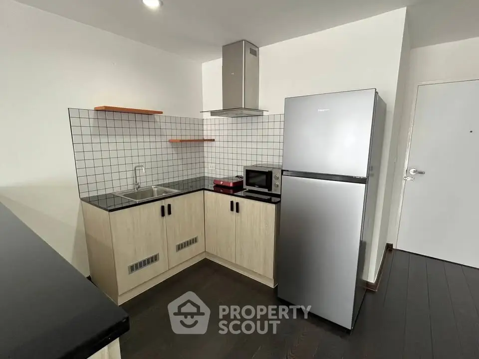 Modern kitchen with sleek appliances and stylish cabinetry in a contemporary apartment.