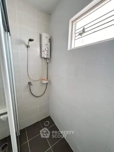 Modern bathroom with sleek shower and natural light from window