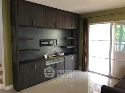 Modern living room with built-in entertainment center and large window for natural light.