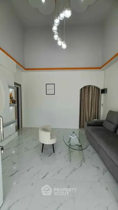 Modern living room with high ceiling, elegant lighting, and stylish furniture in a contemporary home.