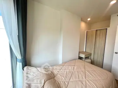 Cozy bedroom with natural light, featuring a comfortable bed and modern wardrobe.