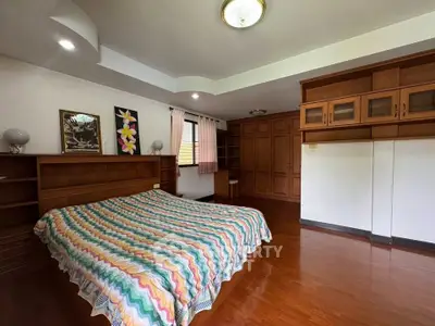 Spacious bedroom with wooden flooring and built-in storage