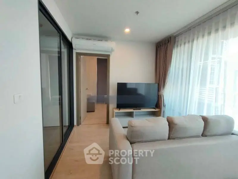 Modern living room with large TV and cozy sofa in bright apartment