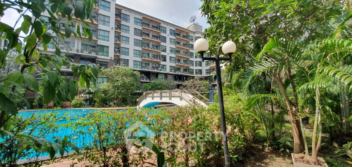 Luxurious residential building with pool and lush garden view