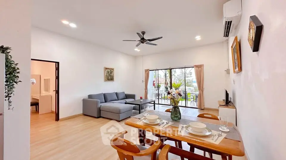 Spacious living room with modern decor and balcony view, perfect for relaxation and entertaining.