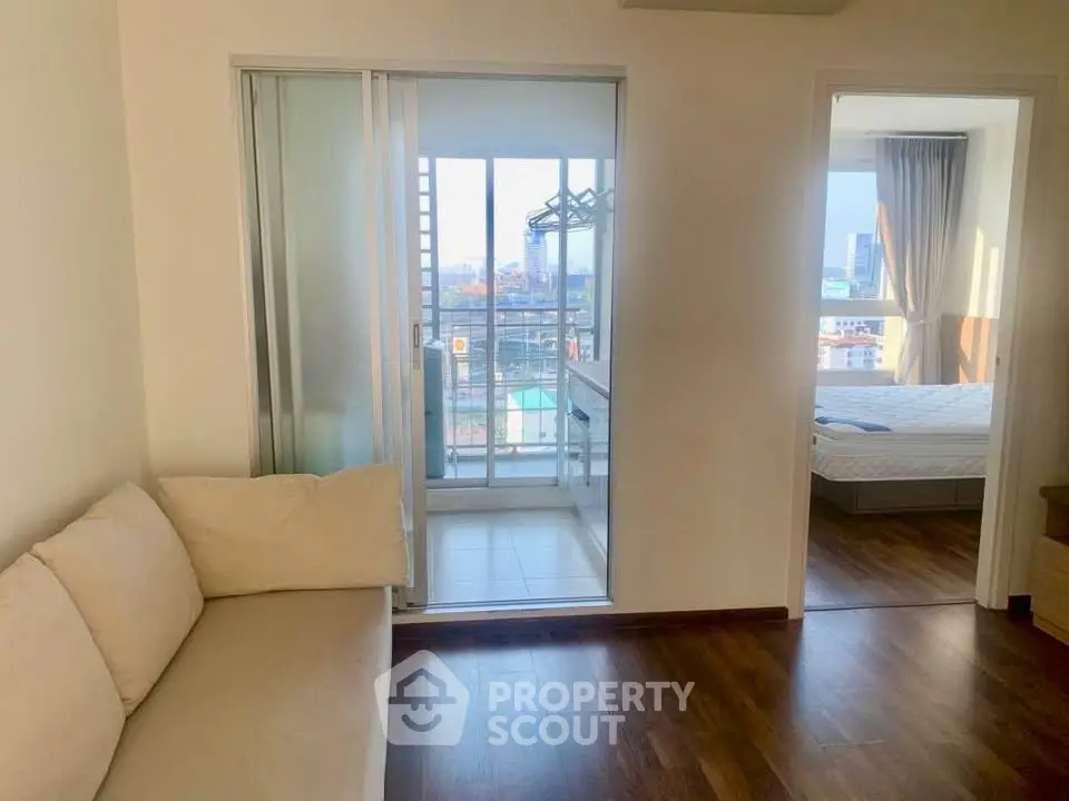 Cozy apartment with balcony view and bedroom access, featuring wooden flooring and modern design.