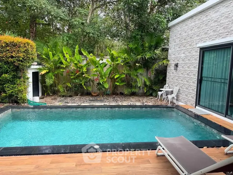 Luxurious private pool with lush greenery and modern patio in serene backyard setting.