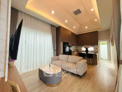Modern living room with open kitchen, stylish furniture, and elegant lighting
