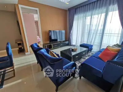 Luxurious living room with elegant blue furniture and large TV, perfect for relaxation.