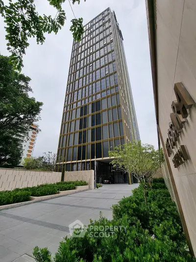 Stunning modern high-rise building with lush landscaping and sleek architectural design.