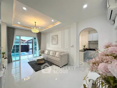 Elegant living room with modern decor and balcony access, featuring a plush sofa and stylish lighting.