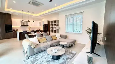 Spacious modern living room with open kitchen, stylish decor, and cozy seating area in a luxury home.