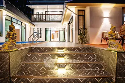 Luxurious villa entrance with elegant lighting and poolside view