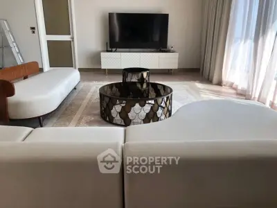 Modern living room with stylish furniture and large TV, perfect for relaxation and entertainment.