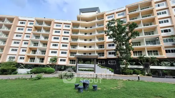 Modern multi-story apartment building with spacious balconies and lush green surroundings.