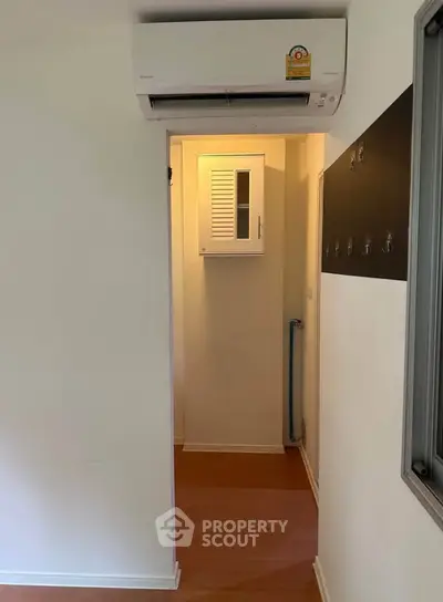 Compact hallway with air conditioning and storage cabinet in modern apartment.