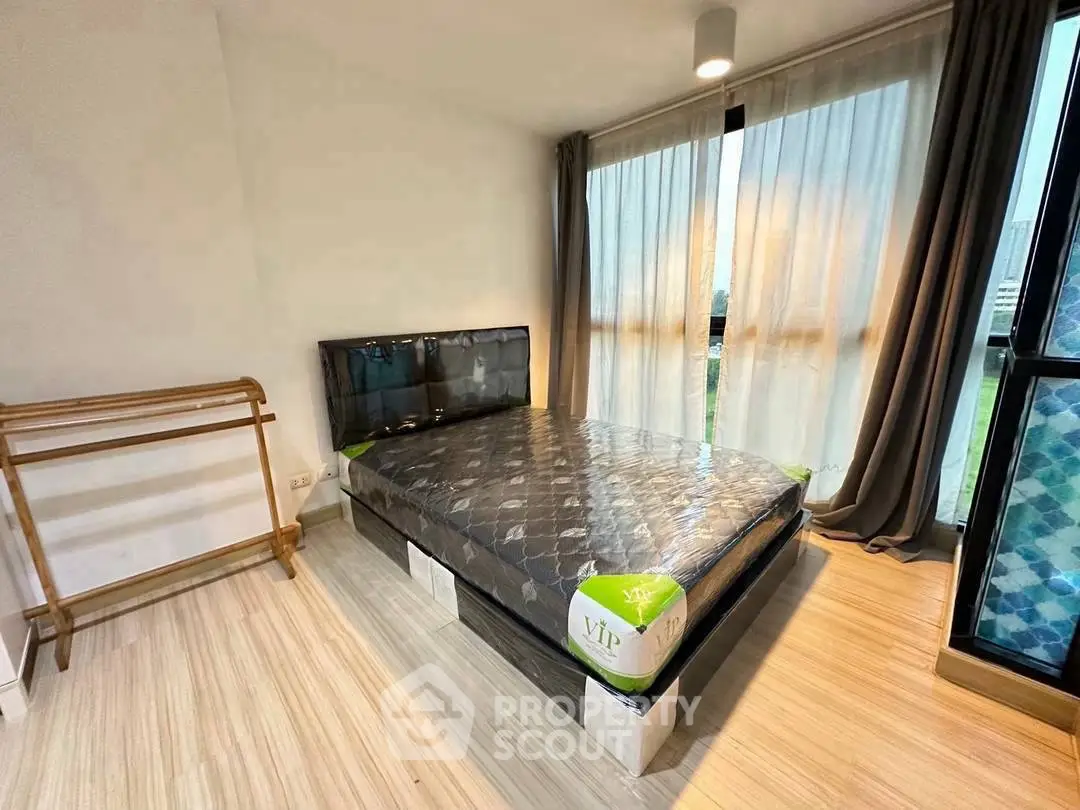 Cozy bedroom with large window and wooden flooring