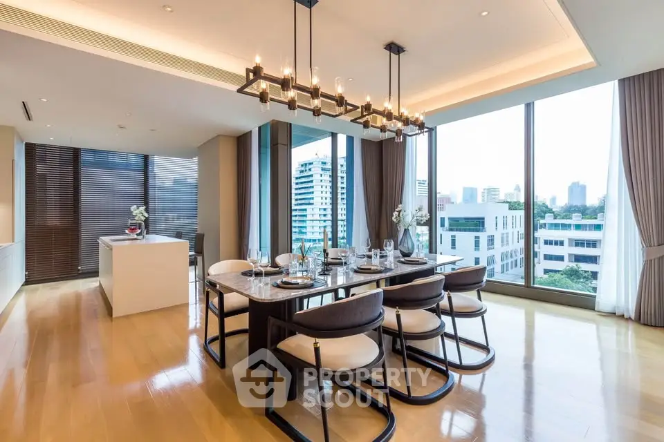 Luxurious dining room with city view, elegant chandelier, and modern furnishings in high-rise apartment.