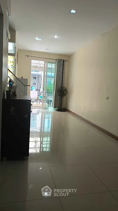 Spacious interior with glossy tiled flooring and large window for natural light.
